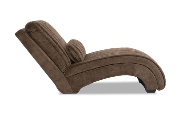 Modern brown fabric chaise lounge chair with curved design, cushioned backrest, and matching round pillow for ergonomic comfort.