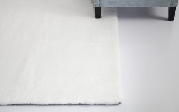 White Angora 5' x 7' transitional rug with plush high pile polyester fabric and charcoal-infused memory foam backing for cushioned comfort.