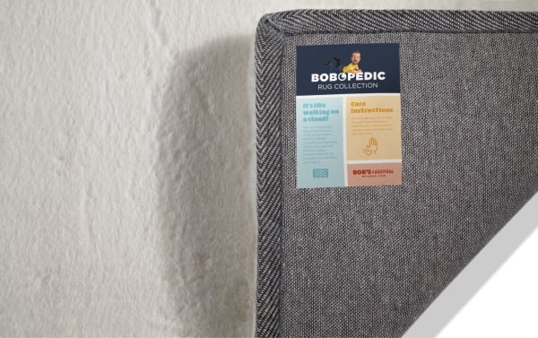 Bob-O-Pedic Angora 5' x 7' white solid transitional rug with plush high pile polyester fabric and charcoal memory foam backing for comfort and odor control.