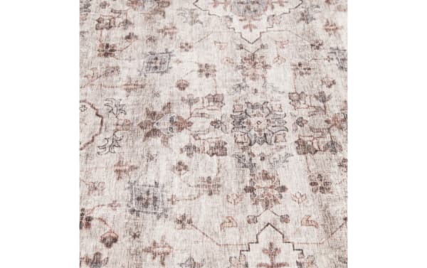 Vintage-style area rug with muted beige background, featuring intricate floral and geometric patterns in soft brown and gray tones, suitable for living room decor.