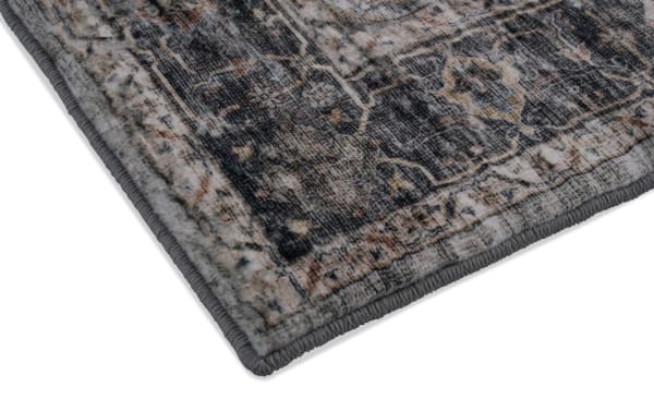 Corner close-up of the Basil 5' x 7' Multi Oriental Rug showing its multicolored transitional design in polyester fabric with charcoal memory foam layer for comfort and odor control.