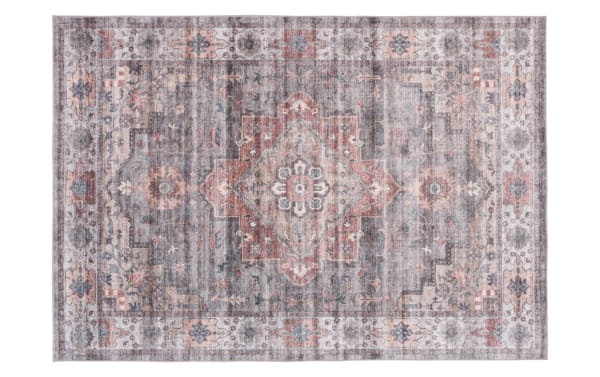 Vintage-style area rug with a distressed pattern featuring muted gray, blush pink, and cream tones, floral and geometric motifs, and a soft textured look.