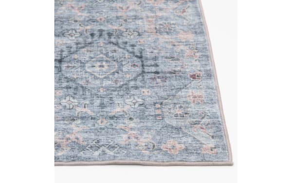 Blue and gray vintage-style area rug with faded floral and geometric patterns, soft textured fabric, and stitched edges.