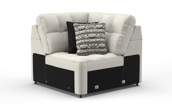 Corner sofa chair with light beige fabric upholstery and black fabric base, featuring tufted cushions and two decorative pillows with patterned and solid black covers.