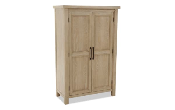 Light wood storage cabinet with two paneled doors, black metal handles, and a natural finish, suitable for home organization.