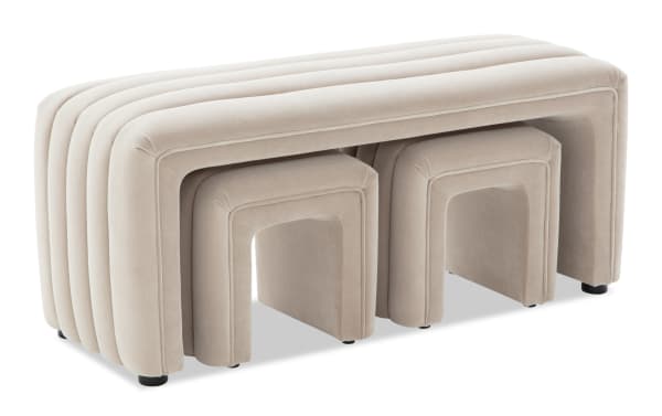 Beige velvet nesting benches with rounded edges and ribbed design, featuring a larger bench with two smaller benches tucked underneath for space-saving seating.