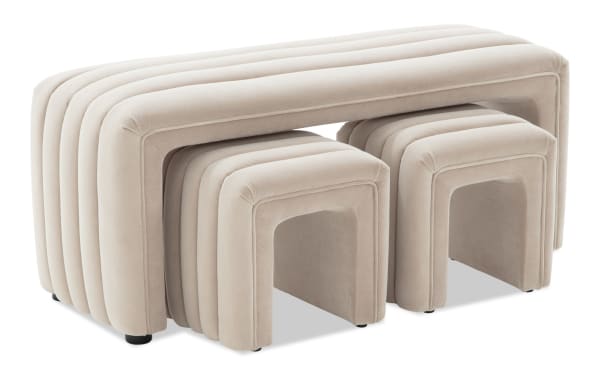 Modern beige velvet nesting tables set with rounded edges and ribbed design, featuring one large table and two smaller stools for versatile living room use.