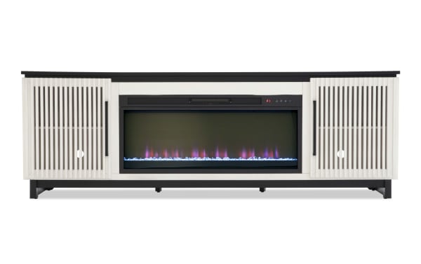 Modern electric fireplace TV stand with white slatted cabinet doors, black metal frame, and realistic LED flame display with blue crystals.