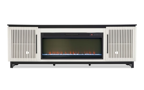 Modern electric fireplace TV stand with white slatted wood cabinets, black metal legs, and a built-in digital fireplace insert with blue and orange flames.