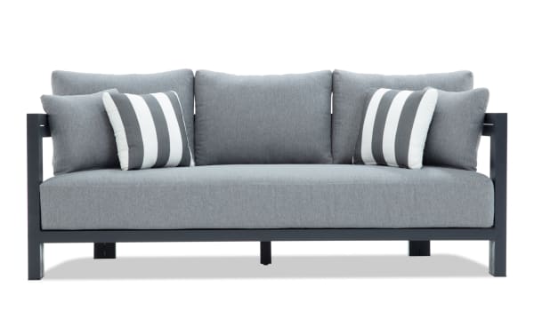Modern outdoor sofa with gray fabric cushions and black metal frame, featuring two striped accent pillows for patio or garden seating.