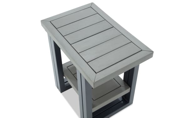 Rectangular outdoor side table with gray slatted wood top and shelf, supported by dark gray metal frame, modern patio furniture design.