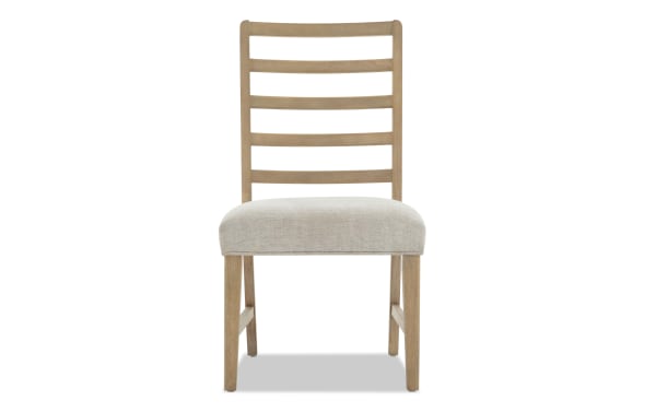 Wooden dining chair with light beige upholstered seat, natural oak finish, and ladder-back design for modern farmhouse style.