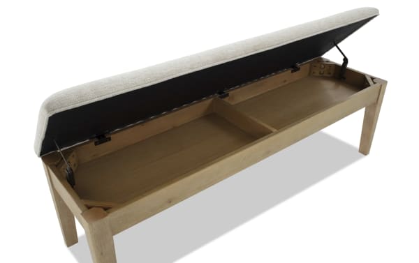 Wooden storage bench with beige upholstered cushioned seat lifted open, revealing divided interior compartment for organizing items.