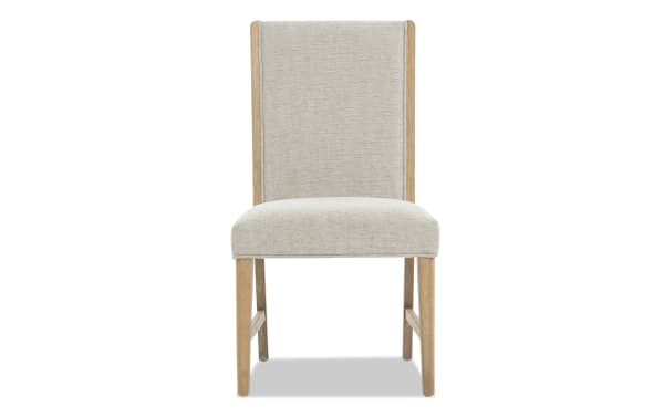 Dining chair with beige upholstered seat and backrest, light wood frame, and simple modern design for home or office use.