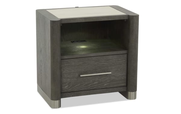 Modern dark gray wooden nightstand with a single drawer, metal handle, open shelf, built-in LED light, and metal feet accents.