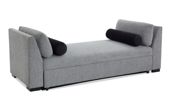 Transitional Daydreamer gray daybed with polyester fabric upholstery, featuring padded arms, two black bolster pillows, and a pop-up sleeper with memory foam for versatile lounging and sleeping.