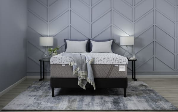 Enchant 16'' Queen Dual Mattress from Enchant collection with gray quilted plush and firm sides, cooling cover, and dual comfort design on black bed frame.