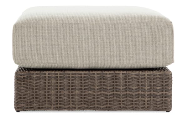 Modular Bob® Beige & Brown Wicker Outdoor Ottoman with all-weather wicker, rust-proof aluminum frame, and beige polyester cushion in transitional style.