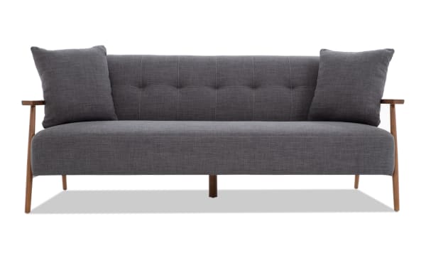Bettie Ash Futon in gray polyester fabric with mid-century modern design, tufted back, wooden arms, and two matching accent pillows.