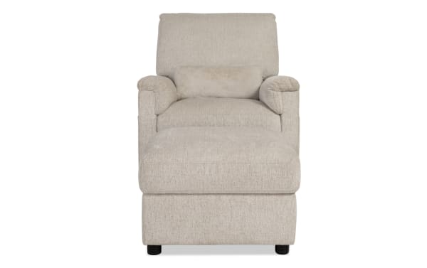 Beige upholstered armchair with matching cushioned ottoman, featuring soft fabric, padded armrests, and a supportive back pillow for comfort.