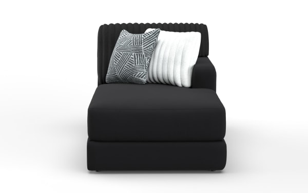 Modern black chaise lounge with ribbed backrest, smooth fabric upholstery, and two decorative pillows in white and geometric gray pattern.