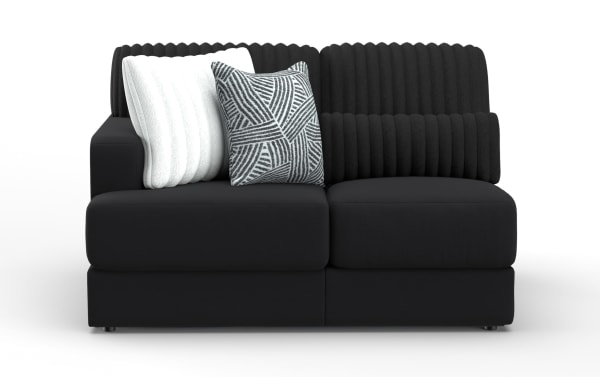 Modern black fabric loveseat with ribbed back cushions, two decorative pillows—one white textured, one gray patterned—ideal for contemporary living rooms.