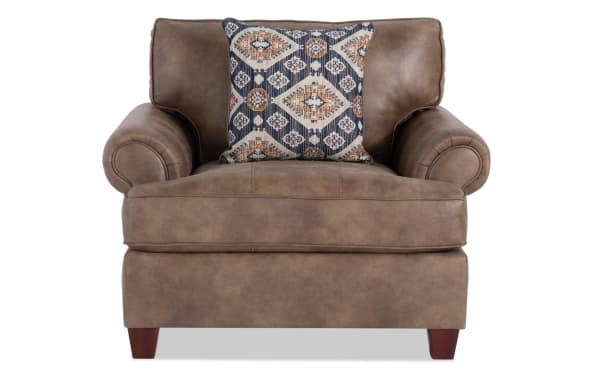 Traditional Raleigh Cognac Chair with brown faux leather polyester upholstery, rolled arms, cushioned back, and patterned accent pillow.