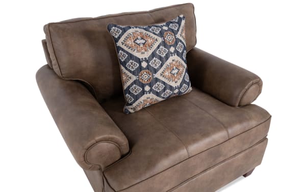 Raleigh Cognac Chair in brown faux leather polyester fabric with traditional style, plush cushions, rolled arms, and patterned accent pillow.