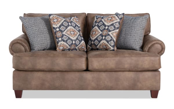 Raleigh Cognac 76'' loveseat in traditional style with brown faux leather polyester upholstery, rolled arms, and four patterned accent pillows.