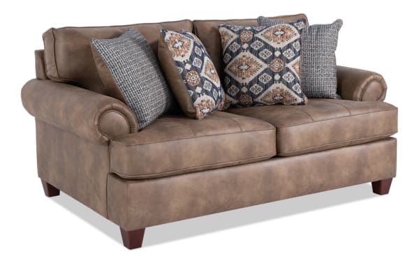 Raleigh Cognac 76'' loveseat in traditional style with brown faux leather polyester upholstery, rolled arms, memory foam cushions, and patterned accent pillows.