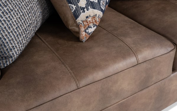 Traditional Raleigh Cognac 76'' Loveseat with brown faux leather polyester upholstery, detailed stitching, and patterned accent pillows for cozy seating.