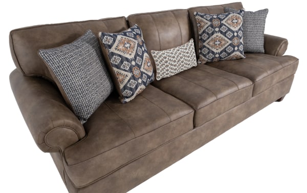Raleigh Cognac 103'' traditional sofa in brown faux leather polyester fabric with rolled arms, memory foam cushions, and patterned accent pillows.
