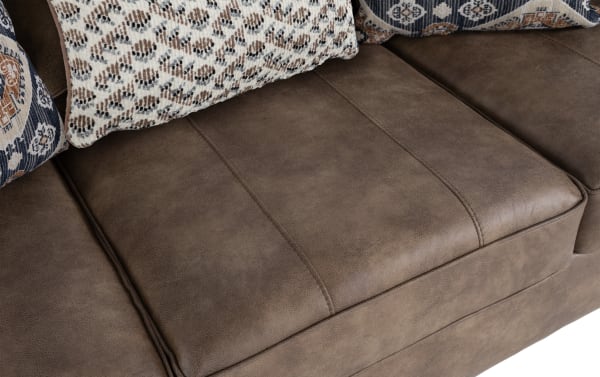 Traditional Raleigh Cognac 103'' Sofa with brown faux leather polyester upholstery, memory foam cushion, and patterned accent pillows.