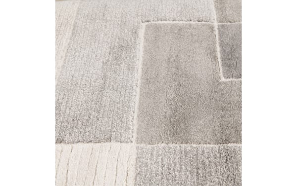 Gray geometric transitional rug with plush, thick polypropylene pile, featuring varied textured blocks in a 9' x 12' Atlas design.