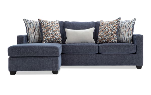 Modern navy blue fabric sectional sofa with chaise lounge, textured upholstery, and decorative multicolor patterned and solid throw pillows.