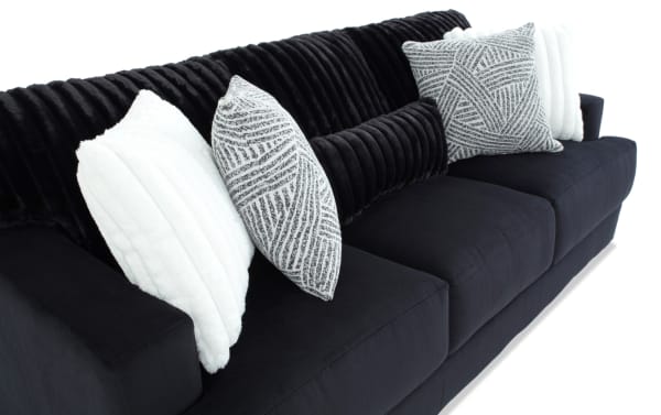Contemporary Sofia Black 93'' Sofa with black polyester fabric upholstery, channel tufted back cushions, and contrasting white and patterned accent pillows.