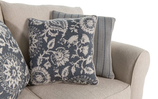 Beige Portland 65'' loveseat with soft polyester fabric upholstery, featuring transitional style and decorative blue-gray patterned and striped accent pillows.