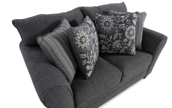Portland Gray 65'' loveseat in transitional style with soft gray polyester fabric upholstery, featuring rolled arms and decorative accent pillows.