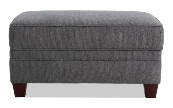 Portland Gray Storage Ottoman in transitional style with soft gray polyester fabric upholstery, cushioned top, and wooden legs for versatile seating and storage.