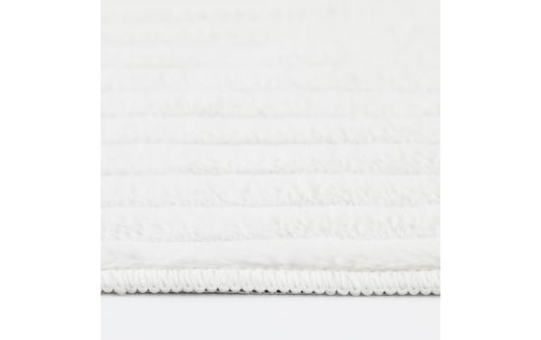 Transitional Sofia 2' x 4' white solid washable rug with ultra-plush medium pile, soft polyester fabric, and looped edge detailing.