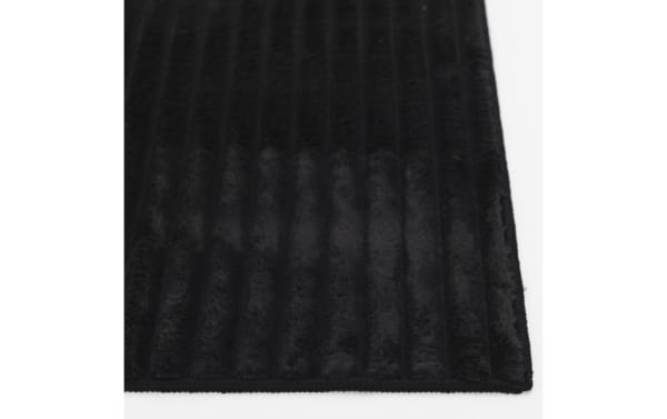 Black Sofia 2' x 4' transitional rug with ultra-plush medium pile, soft polyester fabric, and washable solid design for cozy indoor use.