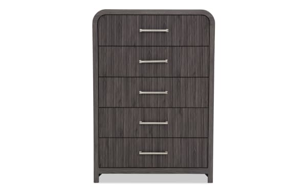 Tall dark gray wooden dresser with five vertically aligned drawers, featuring horizontal silver handles and a textured ribbed front design.