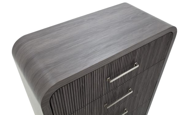 Modern gray wooden dresser with rounded edges, vertical slat drawer fronts, and sleek metal handles, ideal for contemporary bedroom storage.
