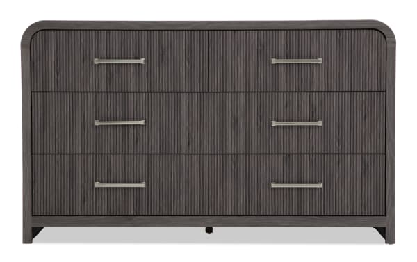 Dark gray wooden dresser with three drawers, vertical groove texture, and sleek metal handles, featuring rounded top corners and modern design.