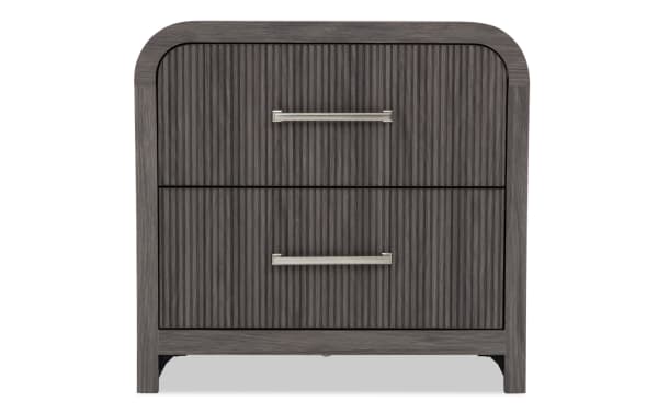 Dark gray wooden nightstand with two vertically grooved drawers, silver metal handles, and rounded top corners, modern style.