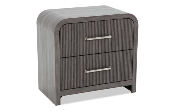 Modern two-drawer nightstand with rounded edges, dark gray wood finish, vertical grooves on drawer fronts, and silver metal handles.