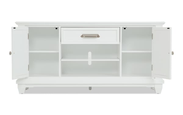 White wooden sideboard cabinet with two open doors showing interior shelves and a central drawer, featuring silver handles and a classic design.