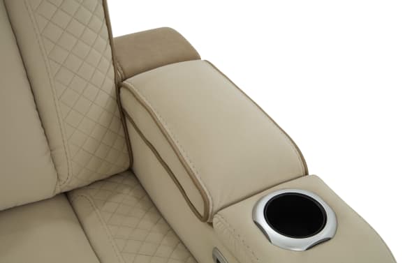 Beige microfiber recliner armrest with quilted stitching, brown piping, and built-in silver cup holder for home theater seating.