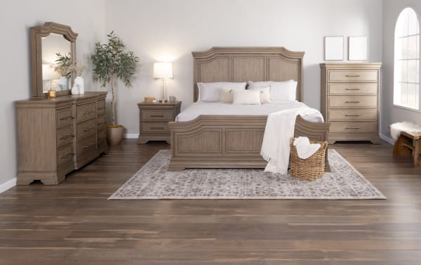 Bedroom set featuring a rustic wooden king-size bed with matching nightstand, dresser with mirror, chest of drawers, and neutral decor on hardwood flooring.