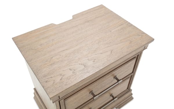 Light wood nightstand with two drawers, featuring silver metal handles and decorative molding, suitable for bedroom storage.